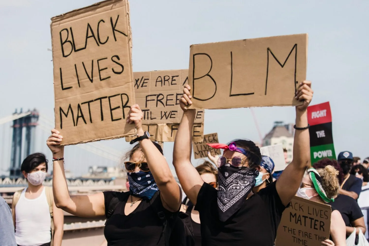 Protestors holding signs at a Black Lives Matter demonstration advocating for justice and equality.