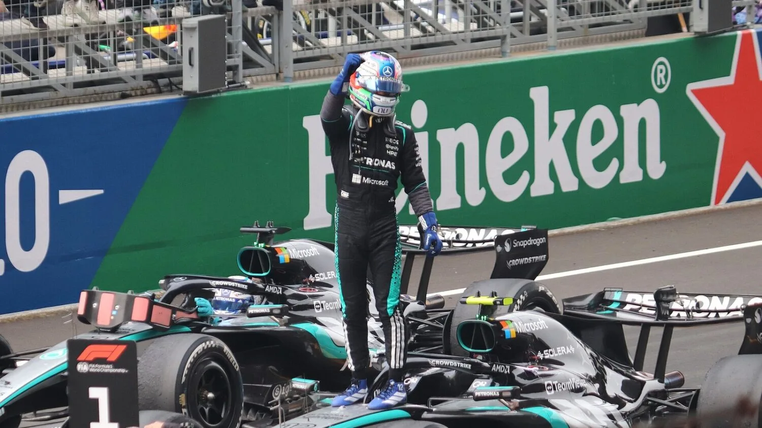 Kimi Antonelli stoi na bolidzie Mercedesa i unosi pięść po wyścigu Grand Prix Chin.