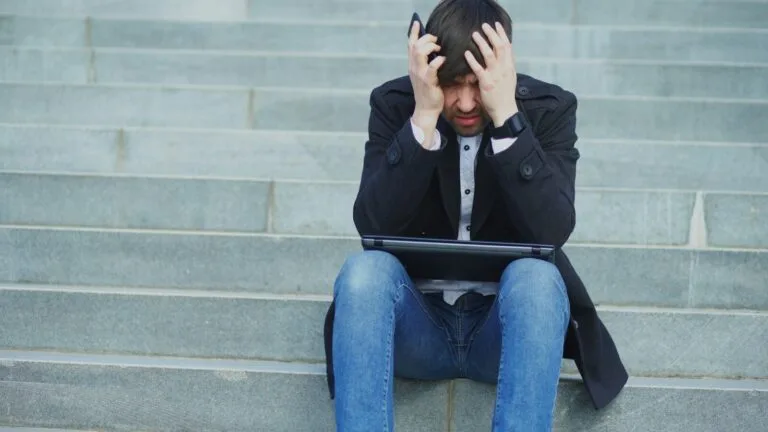 Man sitting on steps with head in hands