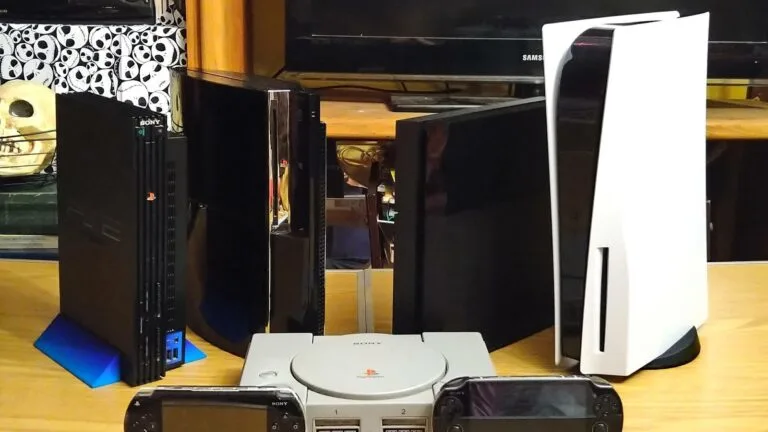 Konsole PlayStation różnych generacji, w tym PS5, oraz przenośne PSP i PS Vita, ustawione na stole
