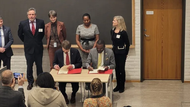 Jean Kaseya, szef Africa CDC, podpisuje porozumienie z norweskim ministrem zdrowia; za nimi stoją inni uczestnicy.