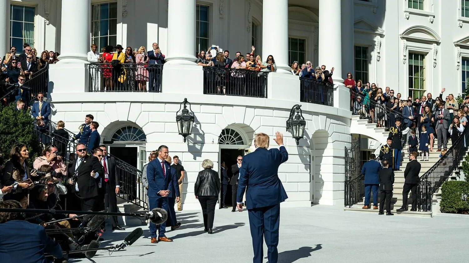 Donald Trump na Południowym Trawniku Białego Domu, machający do tłumu przed wejściem do helikoptera Marine One.