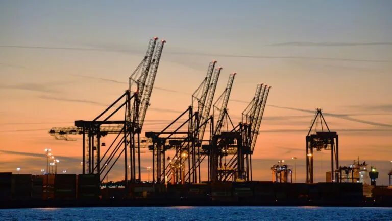 Dźwigi i kontenery w porcie w Gdańsku o zachodzie słońca, nad Zatoką Gdańską, na terenie Deepwater Container Terminal.