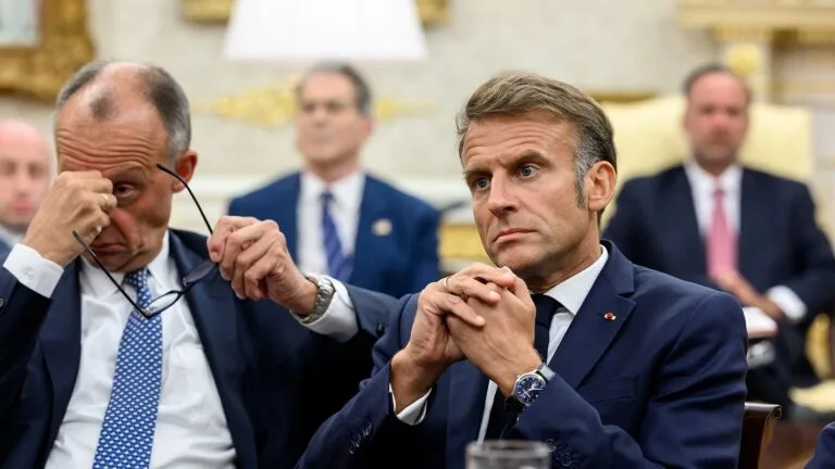 Friedrich Merz i Emmanuel Macron siedzą podczas spotkania z Donaldem Trumpem w Białym Domu, w sierpniu 2025 roku.