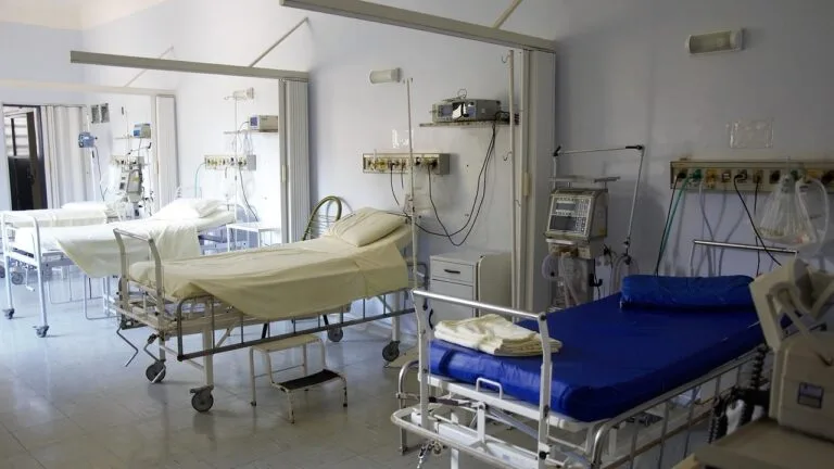 Puste łóżka szpitalne i aparatura medyczna na oddziale szpitala