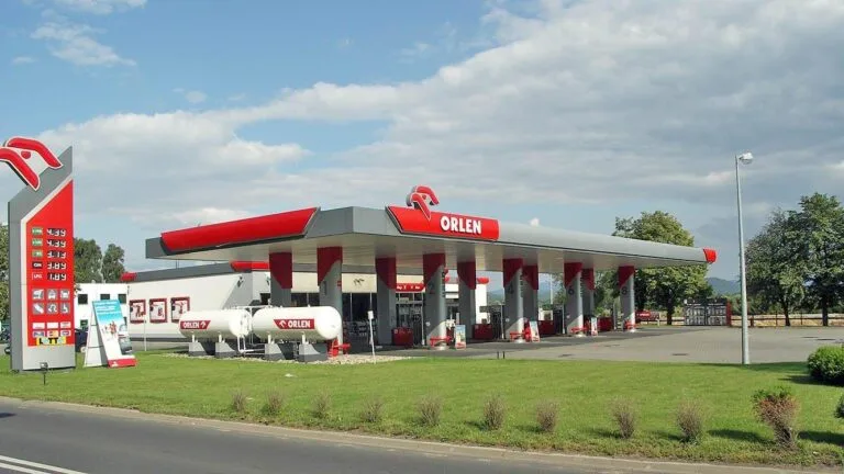 Stacja paliw Orlen w Jeleniej Górze: zadaszone dystrybutory, czerwono-biały słup z logo i zbiorniki na gaz.