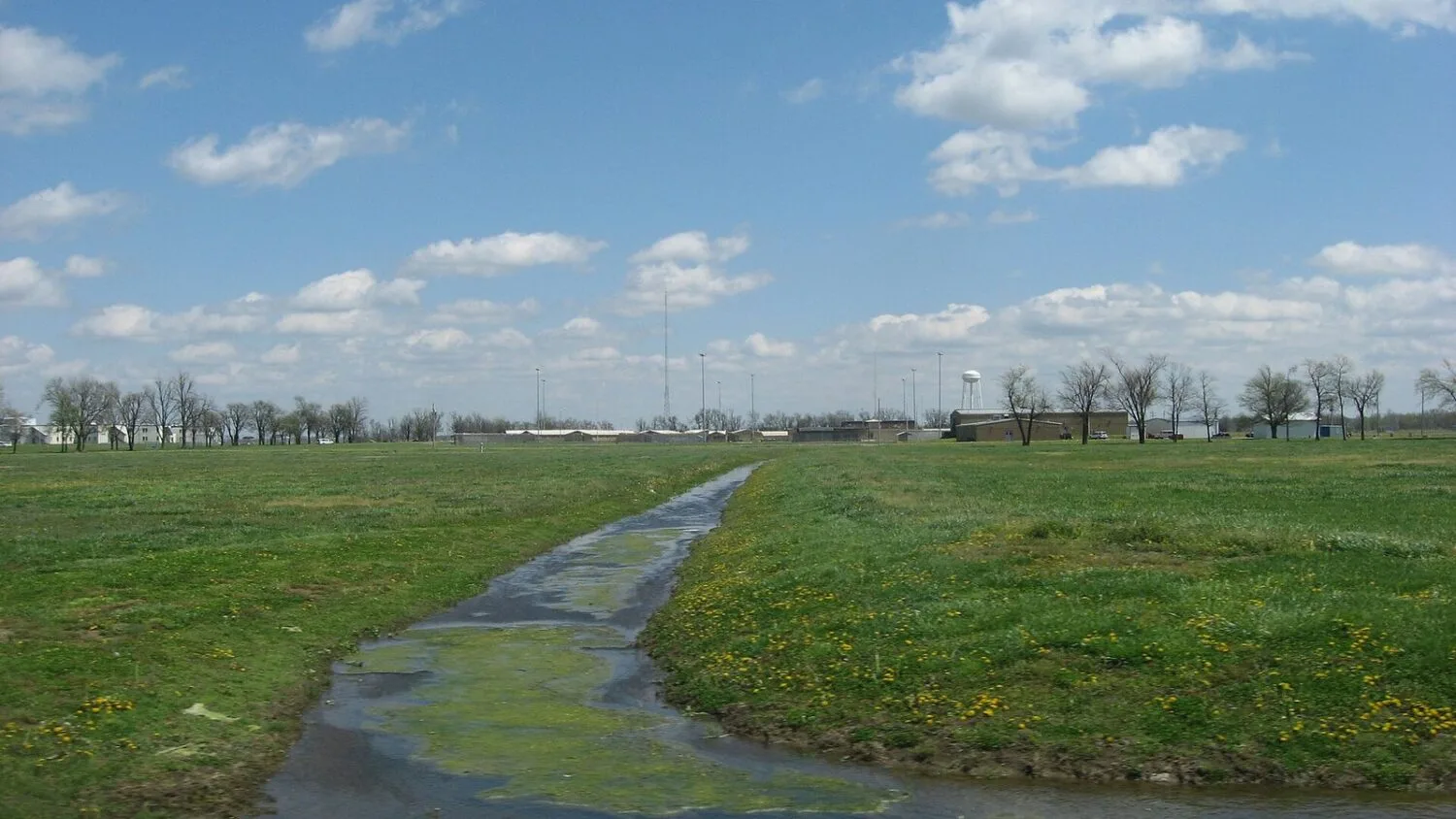 Zakład karny Northwest Correctional Complex w Tiptonville w Tennessee widziany z zachodu: zielony teren, kanał i budynki w…