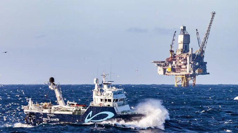 Trawler Roaldnes płynie na fali obok platformy wiertniczej Kvitebjørn na norweskim szelfie Morza Północnego.