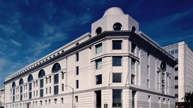 Gmach Sądu Wyższego hrabstwa San Francisco z jasnego kamienia, z łukowatymi oknami i kopułą na dachu.