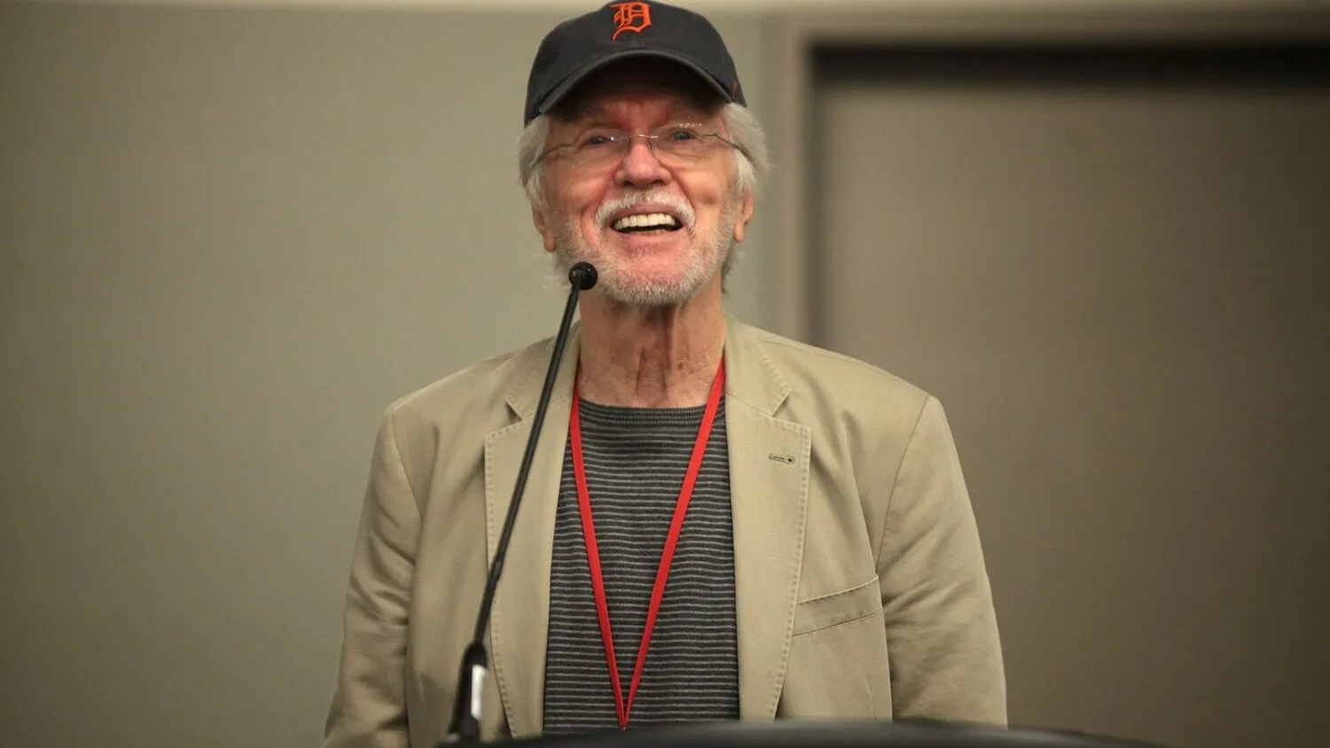 Tom Skerritt w czapce z logo Detroit Tigers i okularach przemawia za mównicą podczas konwentu Phoenix Comicon w 2014 roku.