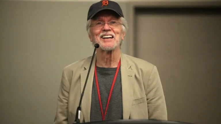 Tom Skerritt w czapce z logo Detroit Tigers i okularach przemawia za mównicą podczas konwentu Phoenix Comicon w 2014 roku.