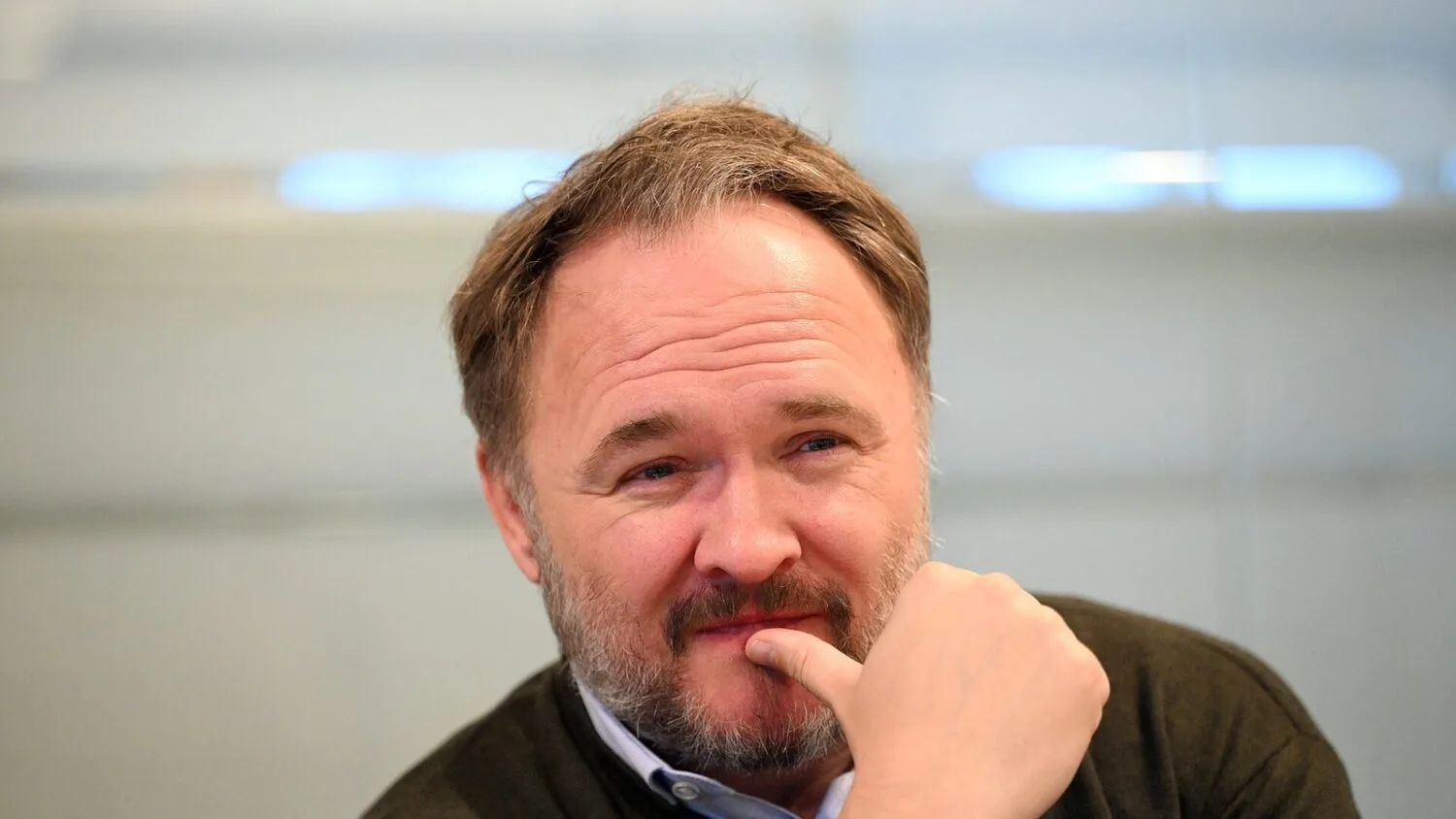 Dan Jørgensen, komisarz UE ds. energii, w ciemnym swetrze, z ręką przy brodzie, siedzi w jasnym pomieszczeniu.