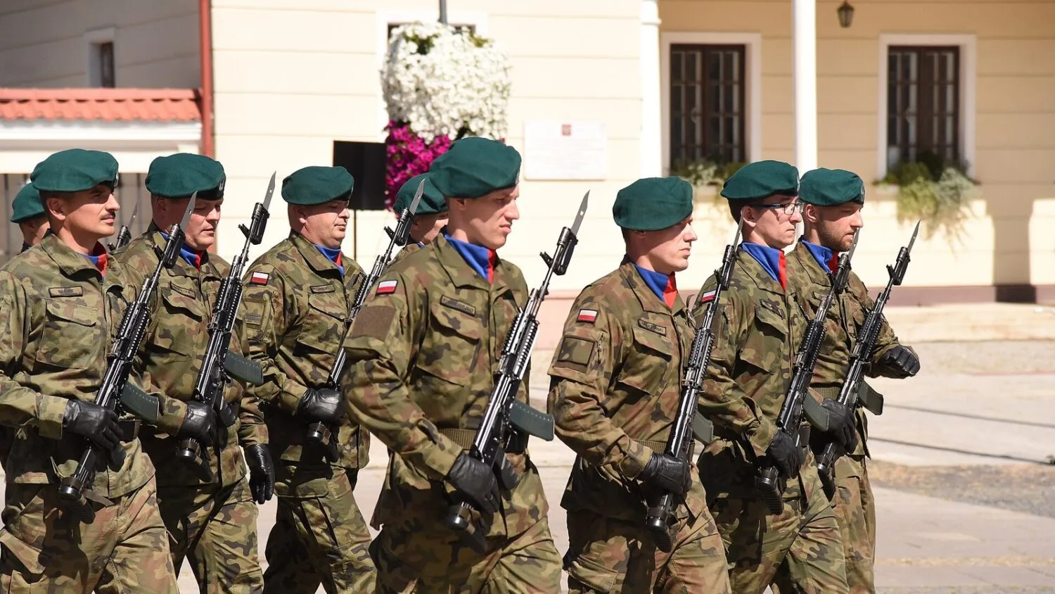 Żołnierze w polowych mundurach i zielonych beretach maszerują podczas uroczystości Święta Wojska Polskiego w Białymstoku.